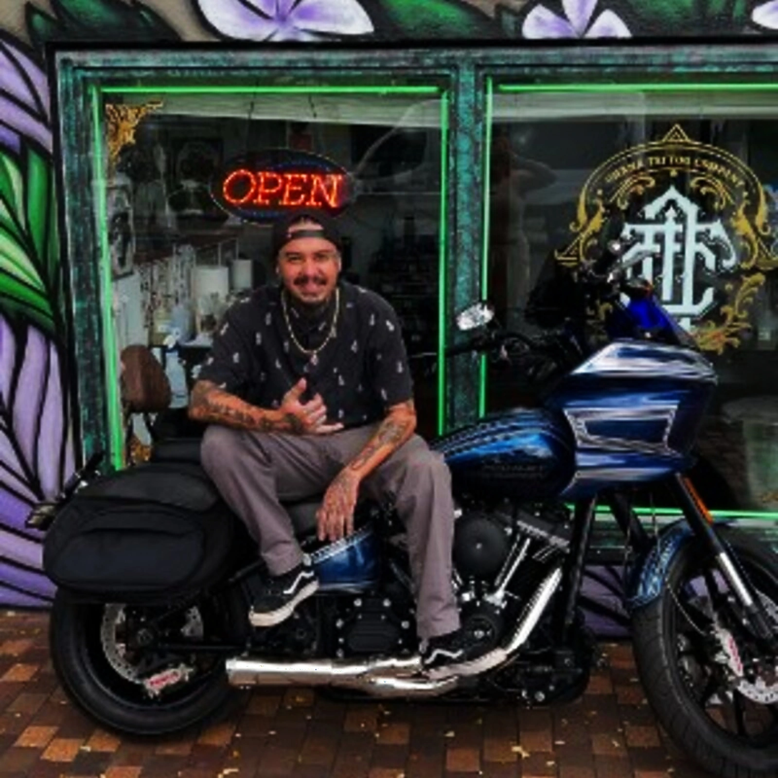 Christian "Tiki" Ramos in front of Ohana Tattoo Company, Waikiki — sitting on his Harley Road Glide outside the storefront with the Ohana Tattoo Company mark visible behind him